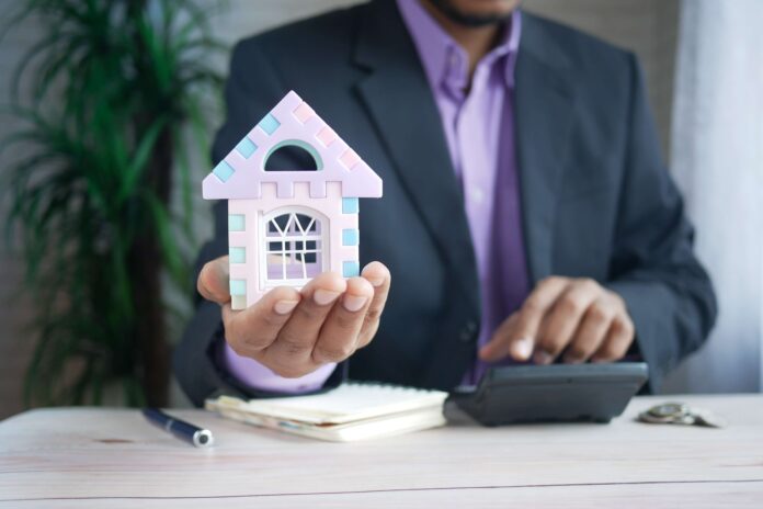 business man holding toy house